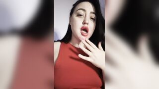 A gorgeous brunette licks her fingers.