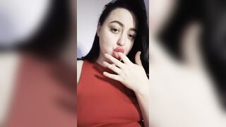 A gorgeous brunette licks her fingers.