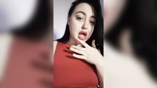 A gorgeous brunette licks her fingers.