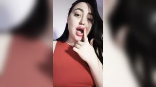 A gorgeous brunette licks her fingers.