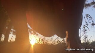 girl peeing with the sunset in the field