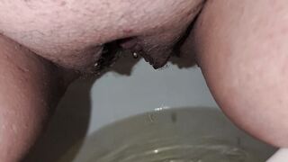 Close up of a piss soaked pussy peeing into a toilet