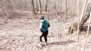 Early spring on bike pissing in the forest near the busy road